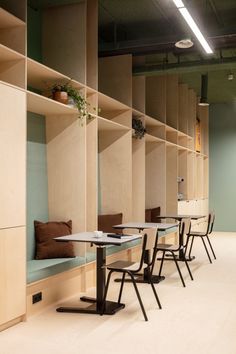 a row of tables sitting next to each other on top of a white floor covered in wooden shelves