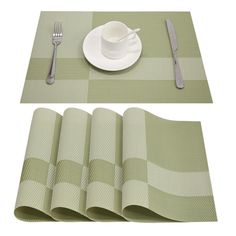 placemats, napkins and silverware are arranged on a green checkered tablecloth