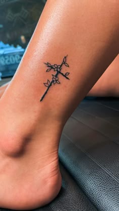 a woman's foot with a cross tattoo on it