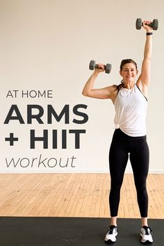 a woman holding two dumbbells while standing in front of a wall with the words at home arms and hit workout