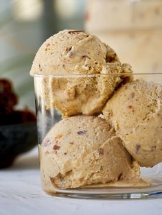 three scoops of ice cream in a glass bowl