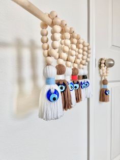 the door is decorated with wooden beads, tassels and eyeballs on it