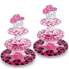 two pink and black cake stands on top of each other with hearts in the middle