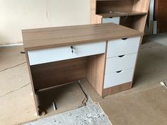 an office desk with drawers and shelves in the middle of a room that is being remodeled