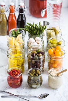 several jars filled with different types of food on a counter next to utensils