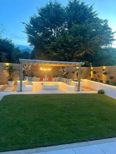 an outdoor living area is lit up at night with lights on the patio and lawn