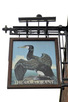 a sign for the cormorant with an image of a bird on it