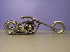 a metal sculpture of a motorcycle on a gray table next to a purple wall and floor