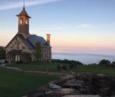 an old stone church with a horse and buggy in the foreground at sunset