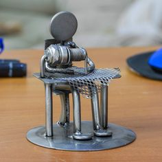 a small metal chair sitting on top of a wooden table next to a cell phone