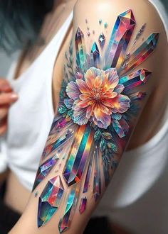 a woman's arm with colorful crystals and flowers on it