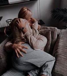 a woman sitting on top of a couch hugging her arm