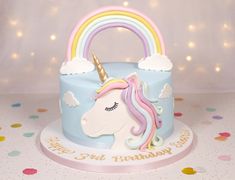 a birthday cake with a unicorn's head and rainbow on top