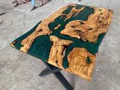 a table made out of wood with green and black paint on it's surface