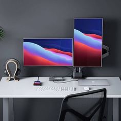 two computer monitors sitting on top of a white desk next to a keyboard and mouse