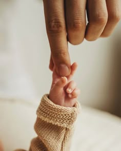 a close up of a person's hand holding the finger of another persons hand