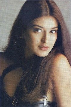 a woman with long brown hair is posing for the camera