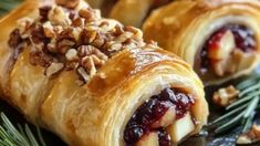 two cranberry and walnut rolls on a platter with pine cones around them