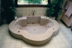 a large jacuzzi tub sitting in the middle of a tiled floored bathroom