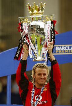 a man holding up a trophy in the air