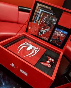 a red box with spider - man action figures in it sitting on top of a couch