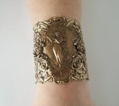 "Art Nouveau Bracelet This beautiful antique brass cuff bracelet has an art nouveau maiden, antique brass chain and lobster clasp. 2.75\" at the widest part. 7\" long adjustable to 9\" long." Art Nuevo Jewelry, Art Nouveau Costume, Gothic Art Deco, Art Nouveau Jewellery, Art Nouveau Jewelry With Historical Design As Gift, Luxury Art Nouveau Wedding Jewelry, Art Nouveau Wedding, Gold Engraved Art Nouveau Jewelry, Art Nouveau Bracelet Jewelry Gift