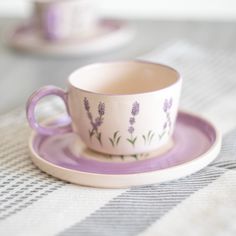 a purple cup and saucer sitting on top of a table