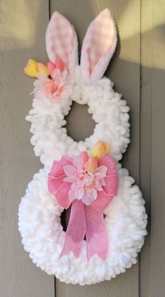 a paper plate bunny wreath hanging on the side of a door