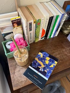 a wooden table topped with books and a vase filled with flowers