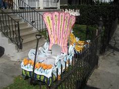 a pink chair sitting on top of a lush green field next to a metal fence