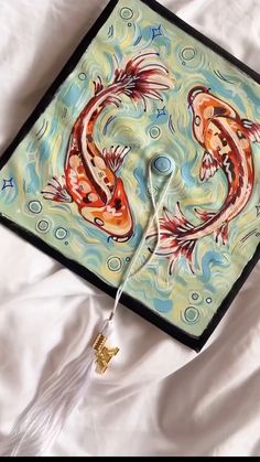 an artisticly designed square piece of art with two fish on it's side