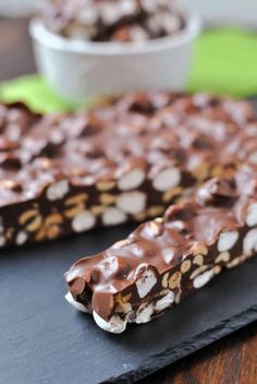 chocolate and marshmallow barkle candy bar on a black slate board with a white bowl in the background