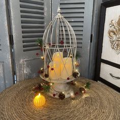 a white birdcage filled with candles sitting on top of a table