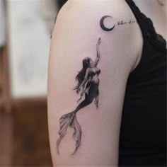 a woman with a mermaid tattoo on her arm