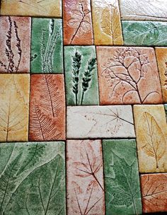 several different colored tiles with leaves and plants drawn on them, all in different colors