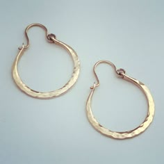 These beautiful sturdy handmade hammered Gold Hoops will quickly become your favourite!  They are made from a thick gauge wire which is forged, filed, hammered, drilled and sanded into form with the finishing touch of a 20g ear wire.  They are made from 14K Gold Filled wire, which will wear well and last for at least our lifetime. Very comfortable and easy to wear.  You can easily wear these 24 hours a day for days on end! These hoops are approximately an inch on the outside diameter and will fall that same from your piercing.  Should you desire these in a larger size, please contact me for a price quote. This listing is for 1 pair of Hoop earrings in your choice of Yellow or Rose Gold Fill. Now offered in Argentium Sterling Silver too! These adorable hoops, as well as all my pieces, are m Small Copper Hoop Jewelry, Hammered, Hammered Copper Hoop Jewelry, Hammered Copper Round Hoop Earrings, Rose Gold Hoop Earrings With Brass, Gold Electroformed Hoop Earrings, Rose Gold Brass Hoop Earrings With Ear Wire, Copper Hammered Hoop Earrings As Gift, Hammered Copper Hoop Earrings As Gift, Hammered Rose Gold Brass Earrings