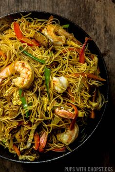 shrimp and noodle stir fry in a skillet with the words singapore noodles above it