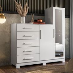 a white cabinet with drawers in a room next to a bed and lamp on the wall