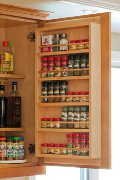 an open cabinet with spices and condiments in it