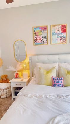 a bedroom with white bedding and yellow pillows