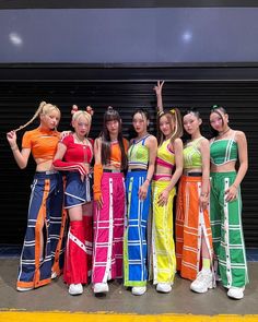 a group of young women standing next to each other in front of a garage door