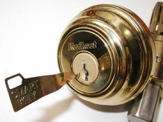 a close up of a metal door lock with a key on the front and side