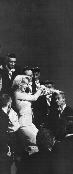 an old black and white photo of a woman in a wedding dress surrounded by other people