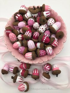 a pink bowl filled with chocolate candies and teddy bears sitting on top of it