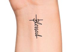 a woman's wrist with the word jesus on it and a cross drawn in cursive writing