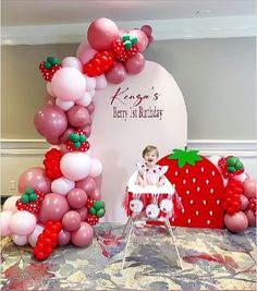 there is a cake and balloons on the table for a birthday party with a strawberry theme