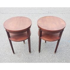 two wooden tables sitting next to each other on the cement ground with no one around them