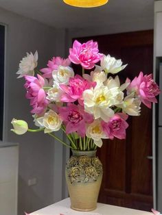 a vase filled with lots of pink and white flowers