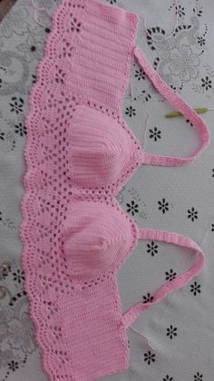 pink knitted bralet laying on top of a doily