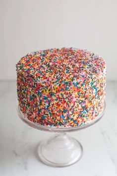 a cake with sprinkles sitting on top of a glass plate